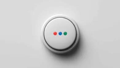 White smart button with red, blue, and green indicator lights on a white surface.