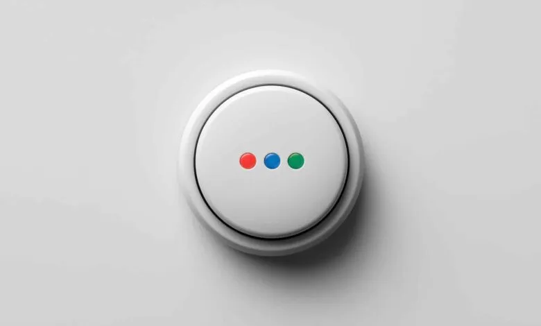 White smart button with red, blue, and green indicator lights on a white surface.