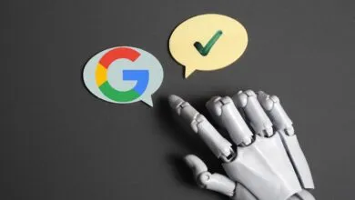 Robot hand points to Google logo and checkmark speech bubbles on gray surface.