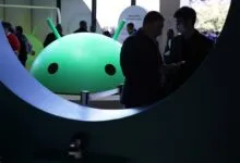 Android logo at event with people, one wearing a mask.