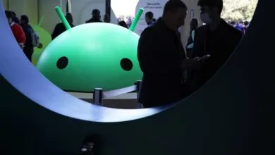 Android logo at event with people, one wearing a mask.