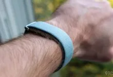Close-up of a wrist wearing a light blue Fitbit fitness tracker.