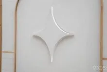 Google Gemini logo, a white starburst, mounted on a textured wall.
