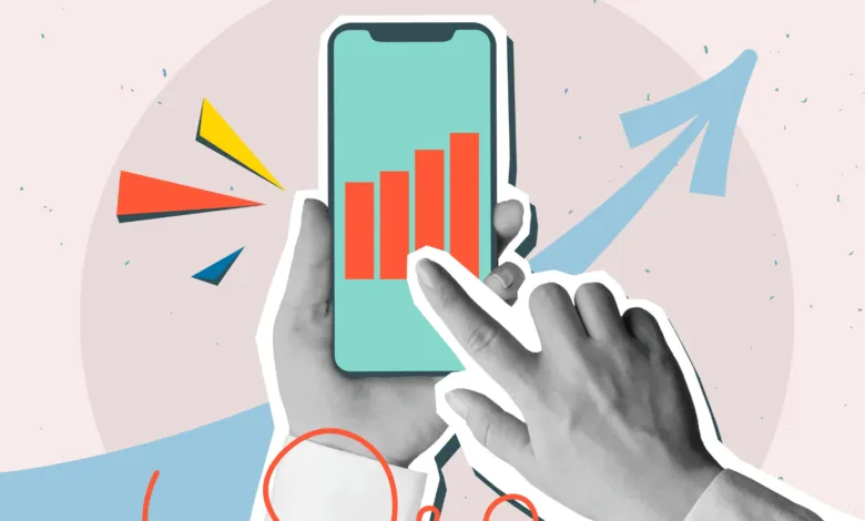 Hands holding phone with rising bar graph, indicating growth.