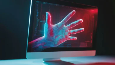 Computer monitor displays a digital hand with red and blue lighting effects.