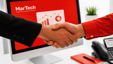 Two people shaking hands in front of a computer screen.