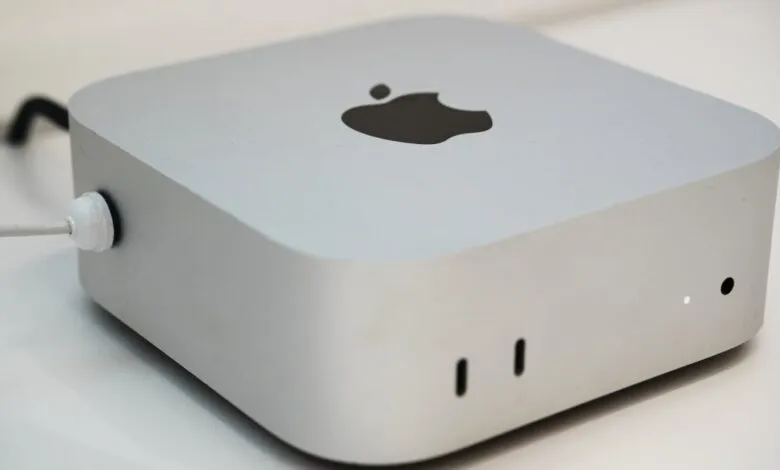 Silver Apple Mac Mini desktop computer on a white surface.