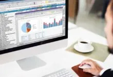 Person working on a computer with spreadsheet and charts displayed.