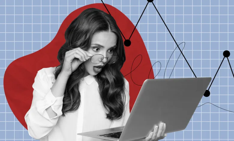 Woman with shocked expression looking at laptop screen.