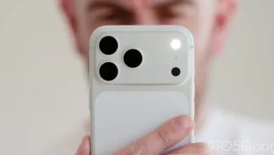 Close-up of a white smartphone camera with three lenses and flash.