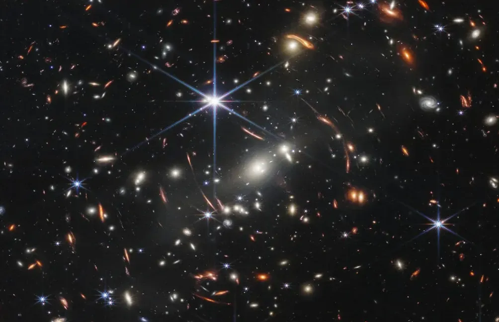 Deep field image showing numerous galaxies of varying shapes and colors.