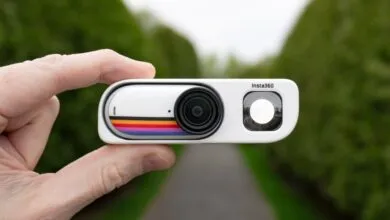 Hand holding a white Insta360 GO 3 camera with retro stripe design.