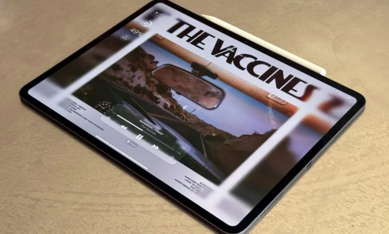 iPad displaying The Vaccines album art with music player controls.