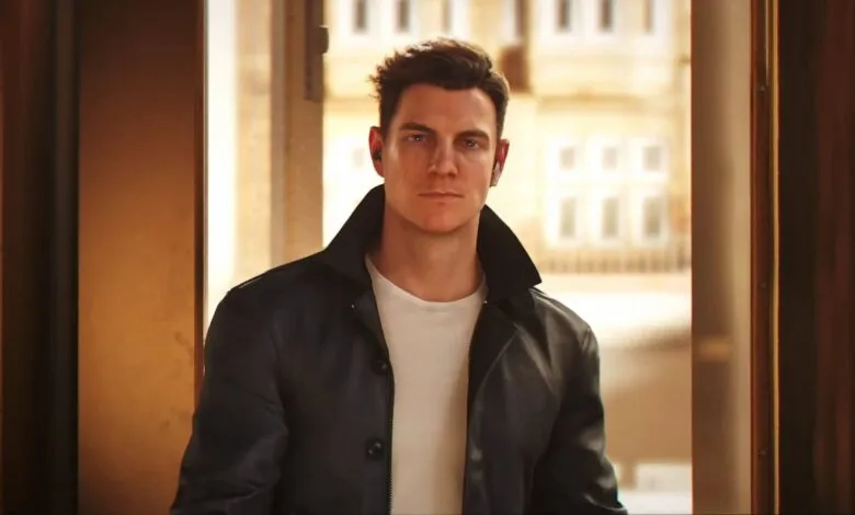 Man in leather jacket and earbuds stands in doorway.