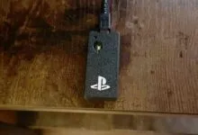 PlayStation USB dongle on a wooden surface, close-up view.