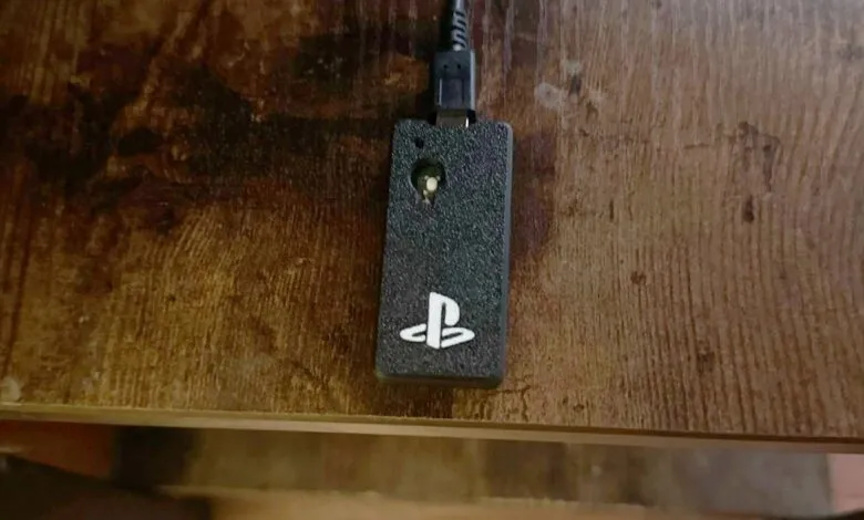 PlayStation USB dongle on a wooden surface, close-up view.
