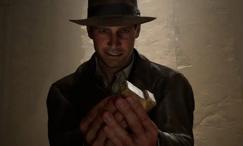 Indiana Jones smiles, holding a golden artifact in a dimly lit tomb.