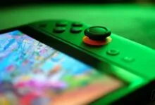 Close-up of a green Nintendo Switch with a game displayed on the screen.