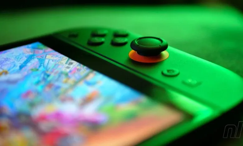 Close-up of a green Nintendo Switch with a game displayed on the screen.