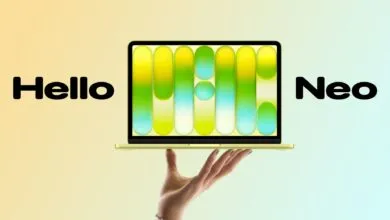 Laptop displaying colorful graphic held by a hand against a gradient background.