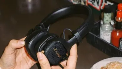Close-up of black Marshall headphones being held in someone's hands.