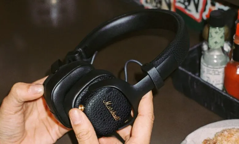 Close-up of black Marshall headphones being held in someone's hands.