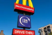 McDonald's restaurant sign with golden arches and drive-thru open 24 hours.
