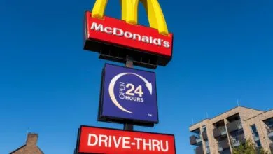 McDonald's restaurant sign with golden arches and drive-thru open 24 hours.