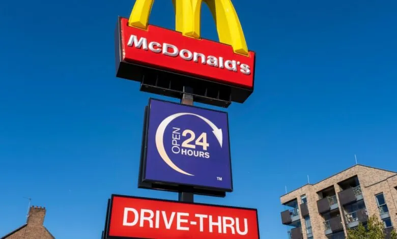 McDonald's restaurant sign with golden arches and drive-thru open 24 hours.