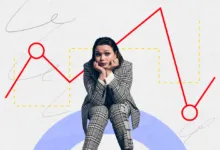 Worried woman in suit sits before a falling stock market graph.