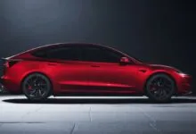 Side view of a red Tesla Model 3 Performance with black wheels.