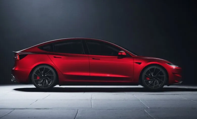 Side view of a red Tesla Model 3 Performance with black wheels.