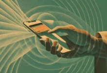 Hand holding phone with credit card on screen, digital payment.