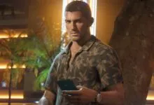 Man in tropical shirt checks phone at night, leaning against tree.
