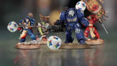 Warhammer 40K miniatures with a colorful die in the foreground.