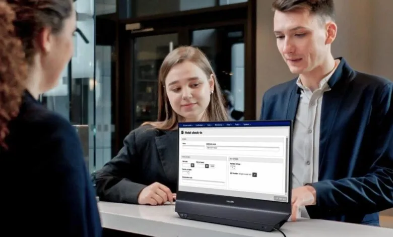Hotel guests check in using a Philips display at the front desk.