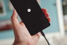 Hand holding a charging smartphone with a lightning bolt icon.