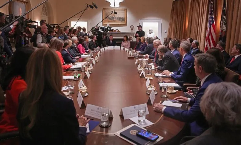 Oval Office meeting with long table, attendees, and press cameras.