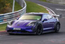 Purple Porsche Taycan Turbo GT with Manthey kit driving on a racetrack.