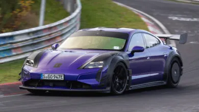 Purple Porsche Taycan Turbo GT with Manthey kit driving on a racetrack.
