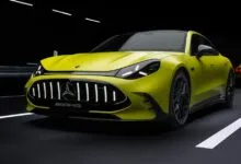 Lime green Mercedes-AMG sports car with black accents on a dark road.