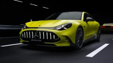 Lime green Mercedes-AMG sports car with black accents on a dark road.