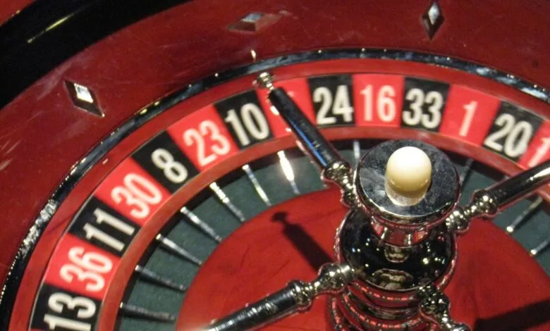 Close-up of a roulette wheel with a ball on the center post.
