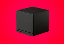 Black cube-shaped device with ports on a vibrant red background.