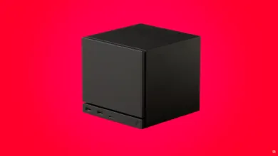 Black cube-shaped device with ports on a vibrant red background.
