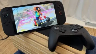 Nintendo Switch with Mario Kart and a black controller on a wooden stand.