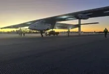 Skydweller aircraft on runway at dawn with ground crew and support truck.