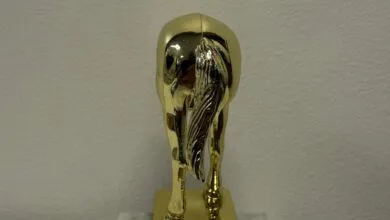 Rear view of a shiny gold horse trophy with a detailed tail.