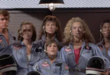 Group of young actors in SpaceCamp movie wearing flight suits and headsets.