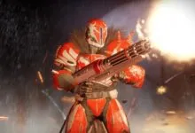 Red and white armored figure holding a large gun in a war-torn environment.